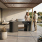 Couple talking at the OVO GL outdoor kitchen under a wooden pergola